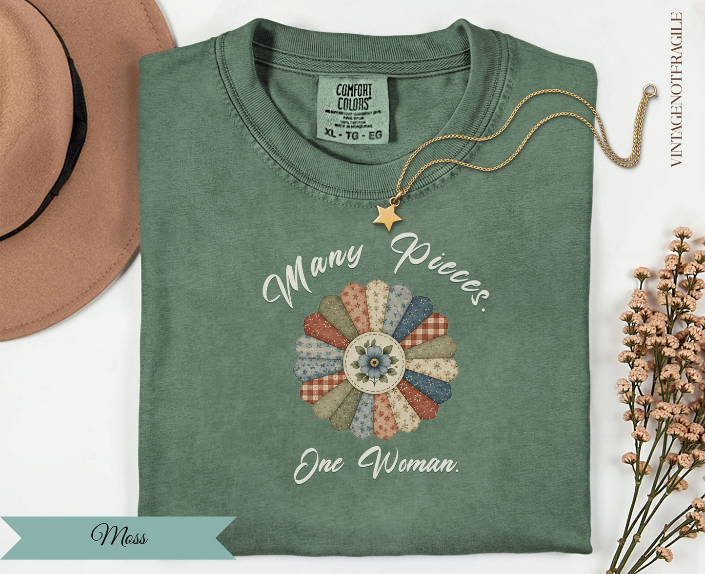 Green t-shirt with "Many Pieces. One Woman." floral applique.