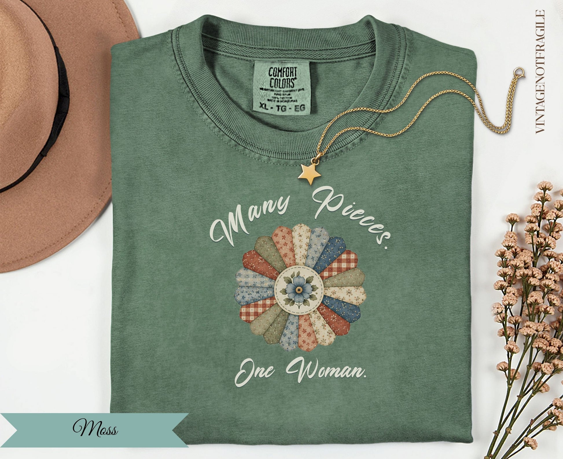 Green t-shirt with "Many Pieces. One Woman." floral applique.