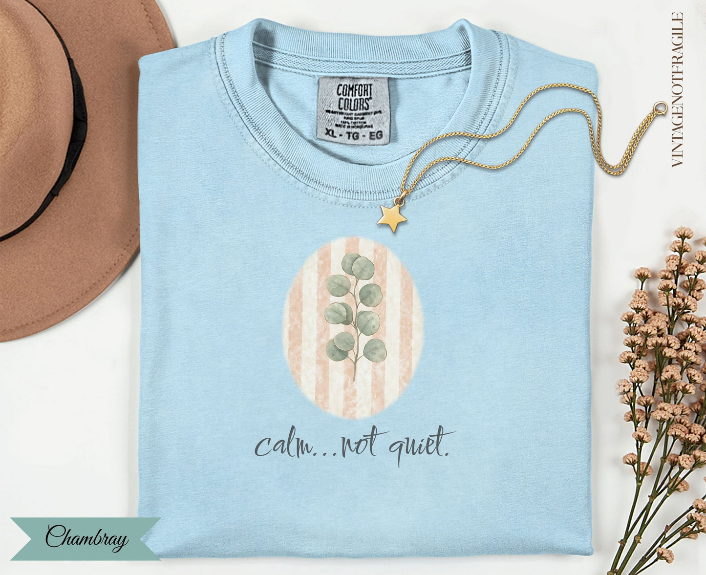 Light blue t-shirt with oval eucalyptus design and "calm...not quiet." text.