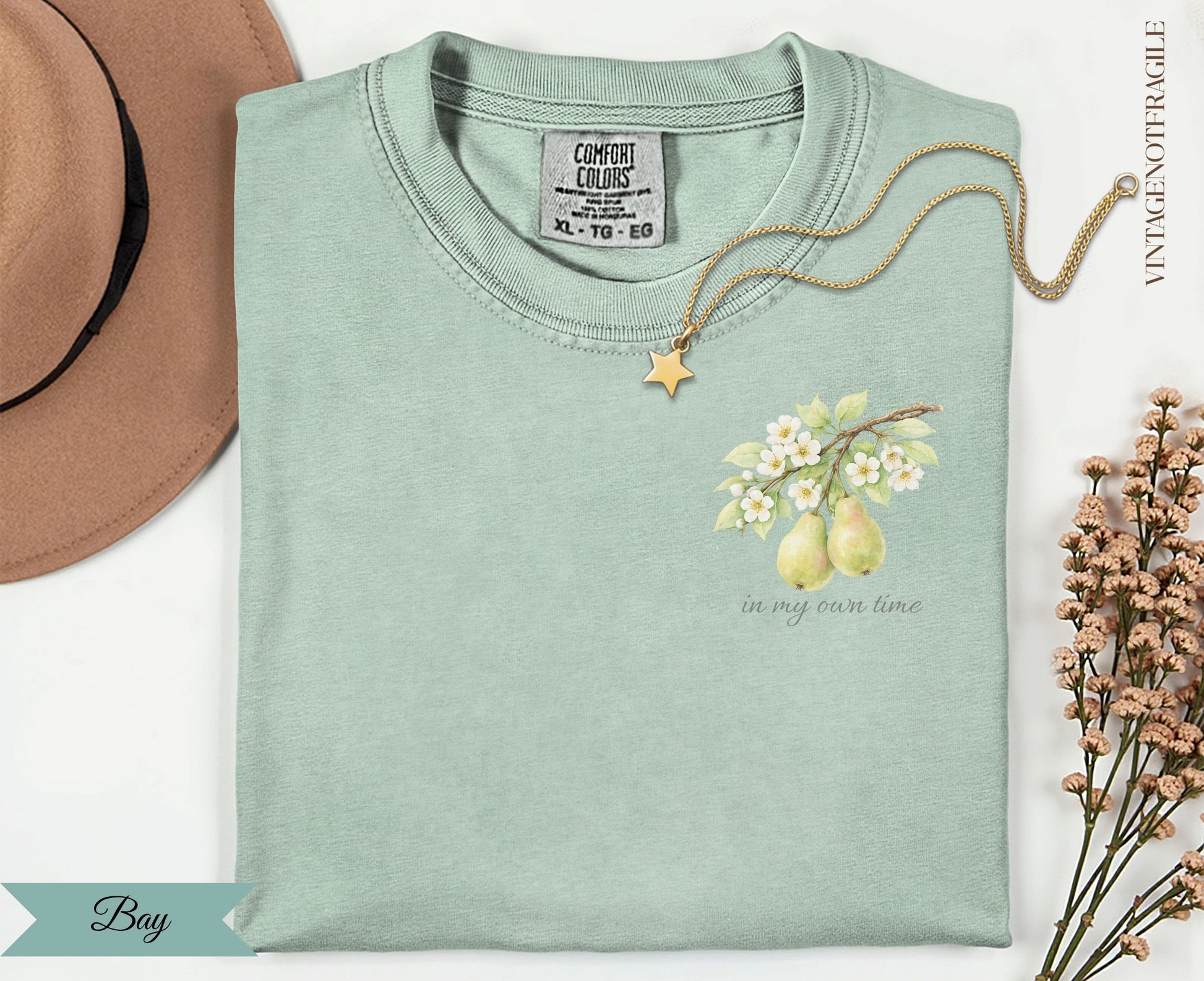 Light green Comfort Colors t-shirt with pears and floral branch graphic and text.