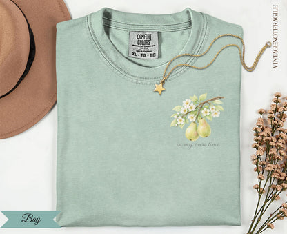 Light green Comfort Colors t-shirt with pears and floral branch graphic and text.
