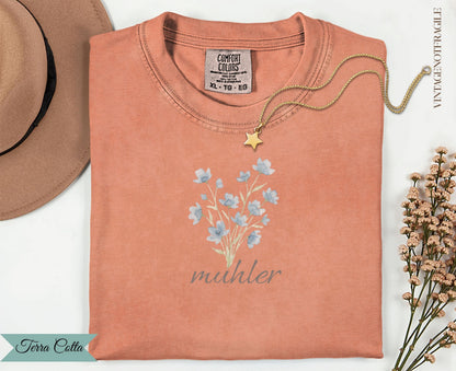 Peach t-shirt with floral illustration and "muhler" text.
