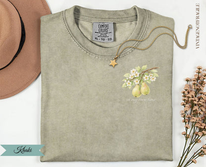 Khaki t-shirt with pear and floral graphic and "in my own time" text.