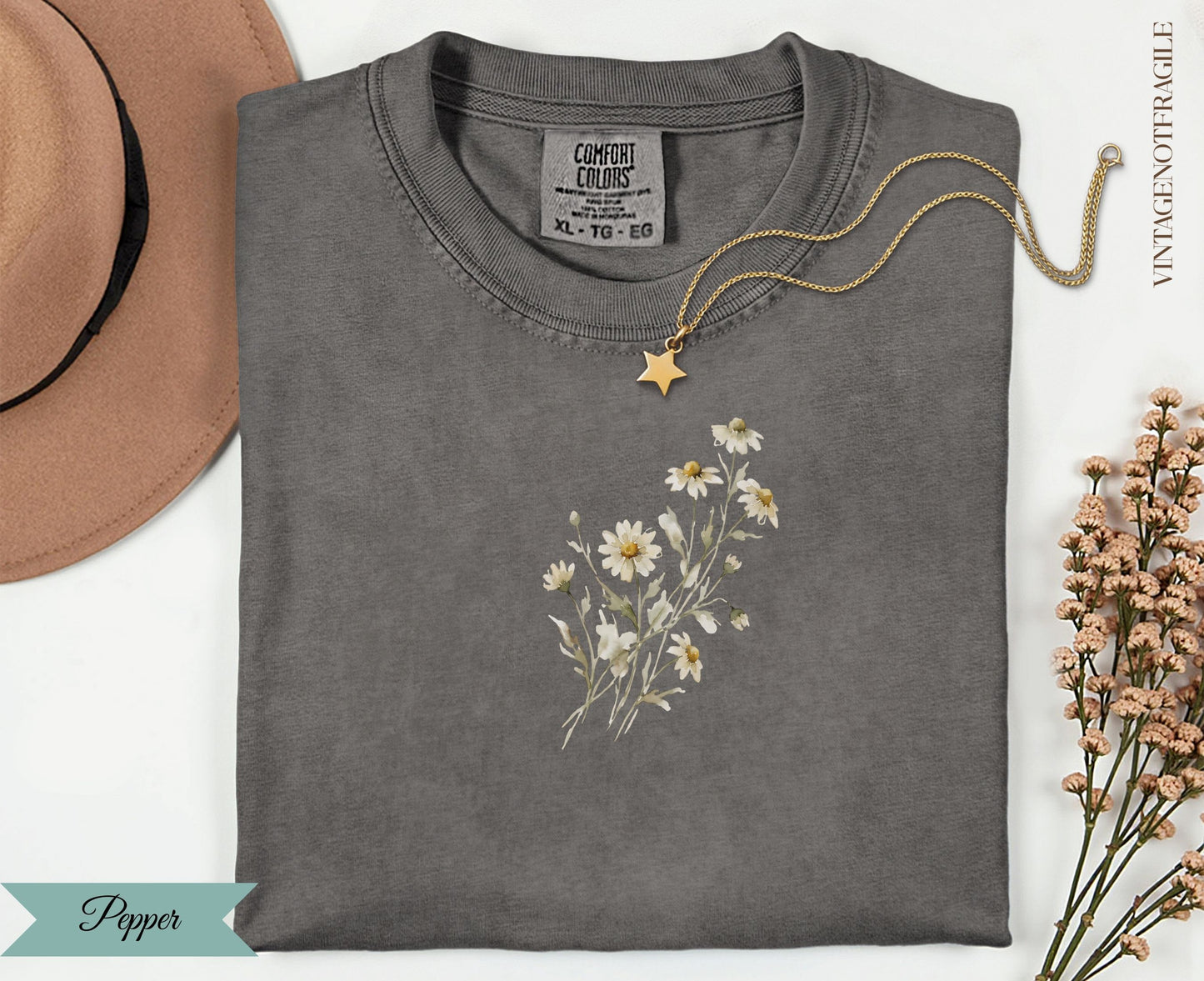 Dark gray t-shirt with white daisy bouquet graphic and gold necklace.
