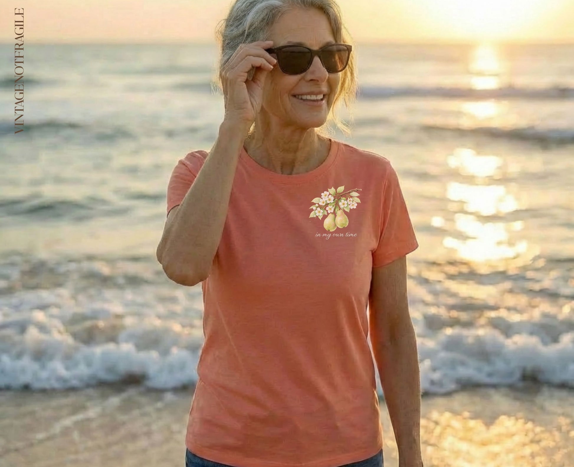 Woman wearing coral t-shirt with delicate floral design and text "in my own time".