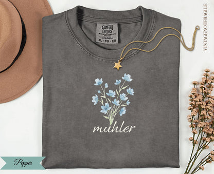 Dark grey t-shirt with blue floral design and "muhler" text.