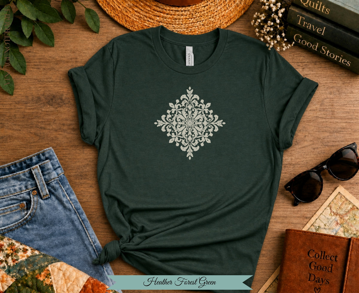 Dark green t-shirt with cream damask design, jeans, sunglasses, and notebook.