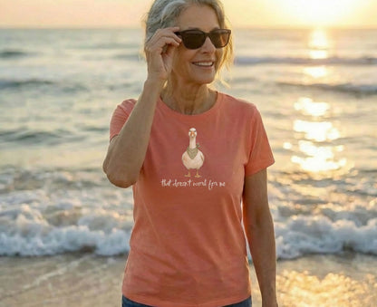 Woman wearing coral t-shirt with a duck graphic and text.