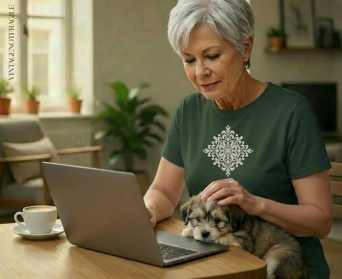 Woman petting a puppy while looking at a laptop with a cup of coffee.