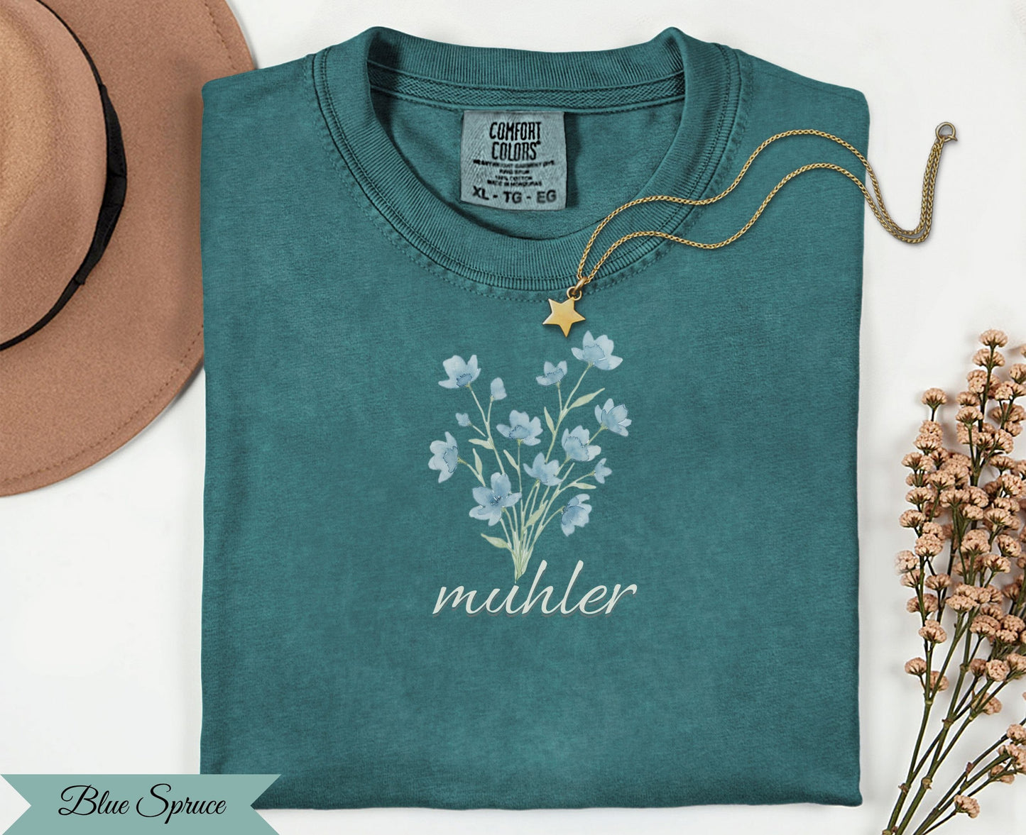 Teal t-shirt with blue floral bouquet and "muhler" text.