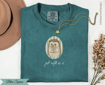 Teal t-shirt with hedgehog wearing a flower crown and text "just right as is".
