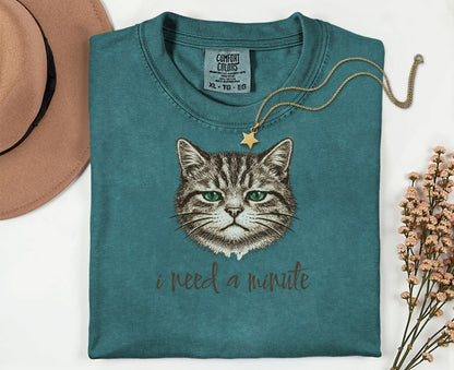 Teal t-shirt with a grumpy cat graphic and "I need a minute" text.