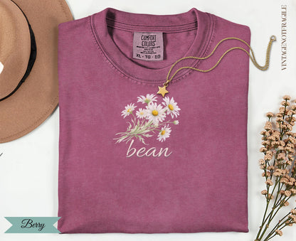 Berry colored t-shirt with "bean" and daisy graphic.