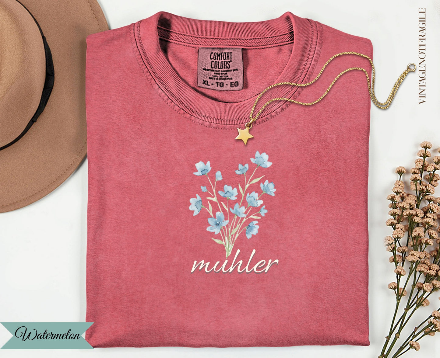 Rose quartz t-shirt with light blue floral design and "muhler" text.