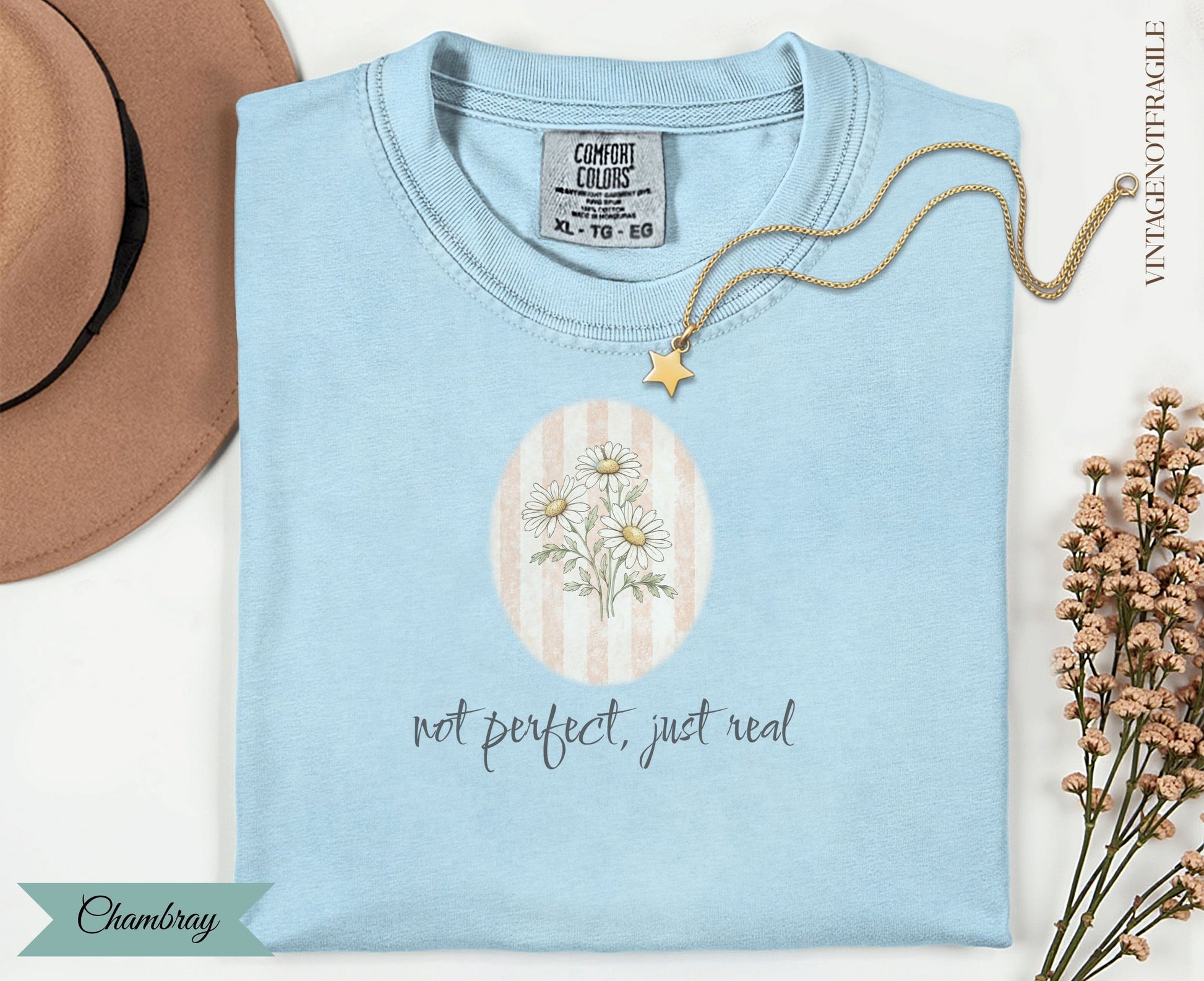 Light blue Comfort Colors t-shirt with "not perfect, just real" text and daisy graphic.