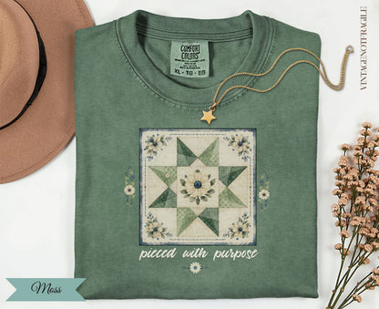 Green t-shirt with a quilted star design and the text "pieced with purpose".