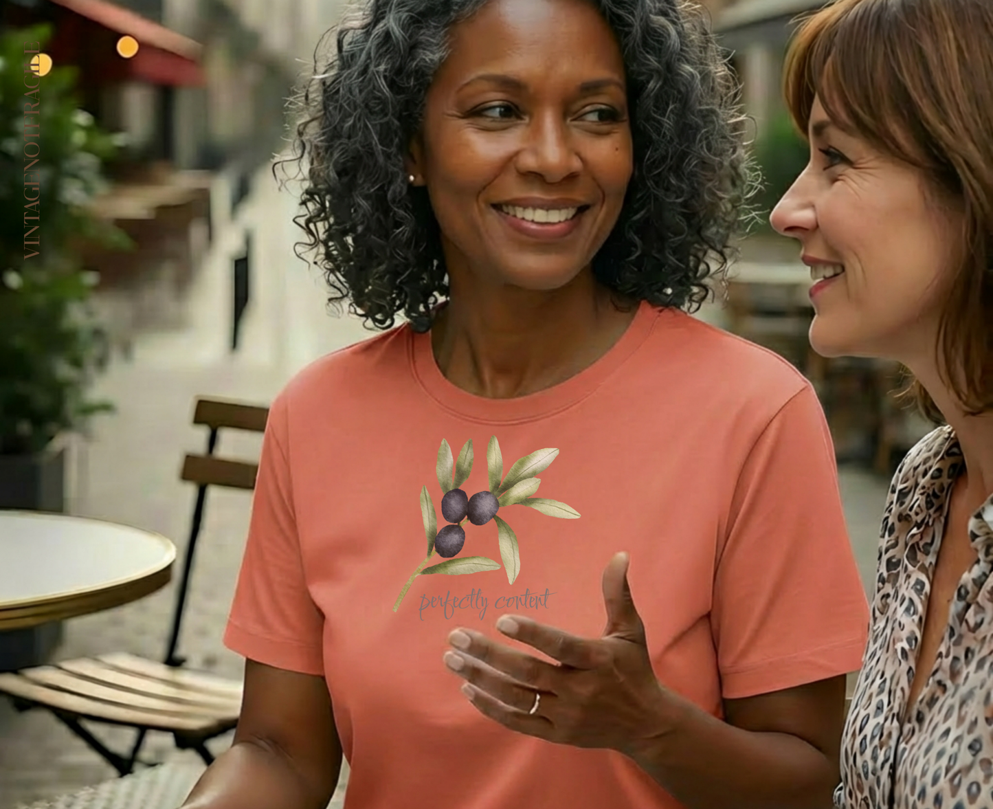 Woman in coral t-shirt with olive branch design.