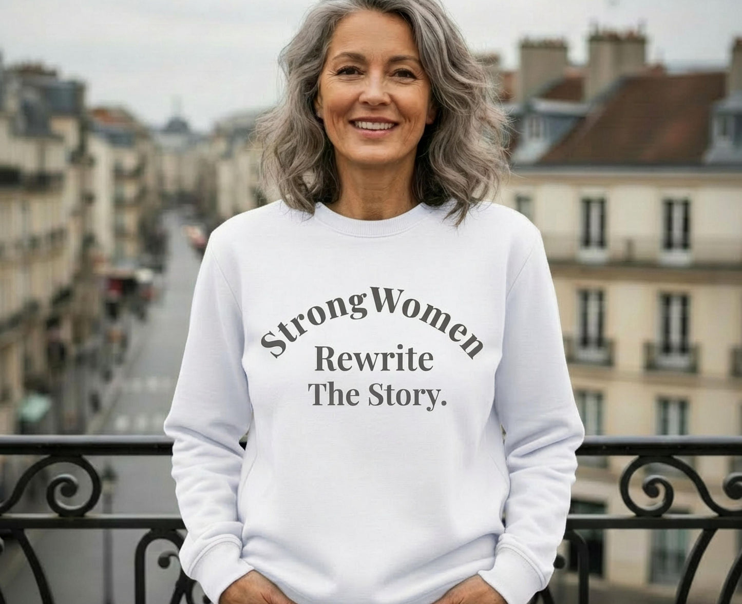 White sweatshirt with text "Strong Women Rewrite The Story."