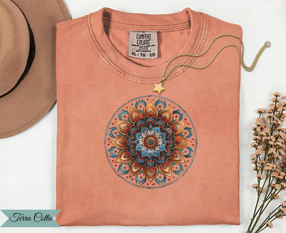 Coral t-shirt with mandala design and gold star necklace.