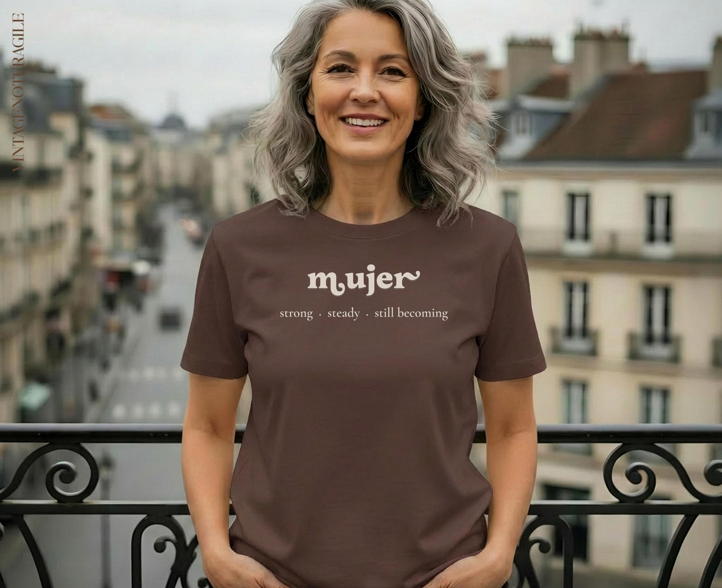 Woman in brown t-shirt with "mujer strong. steady. still. becoming" text.