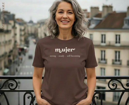 Woman in brown t-shirt with "mujer strong. steady. still. becoming" text.