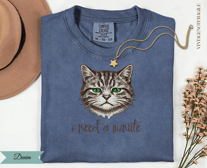 Denim t-shirt with a cat graphic and "i need a minute" text.