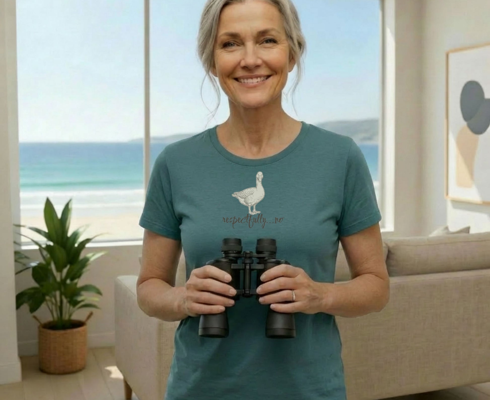 Woman in teal t-shirt with a goose graphic and text "Respectfully...no" holds binoculars.