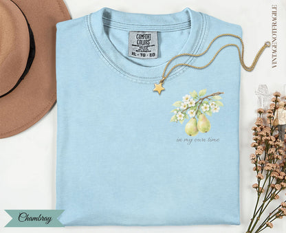 Light blue t-shirt with pear branch design and "in my own time" text.
