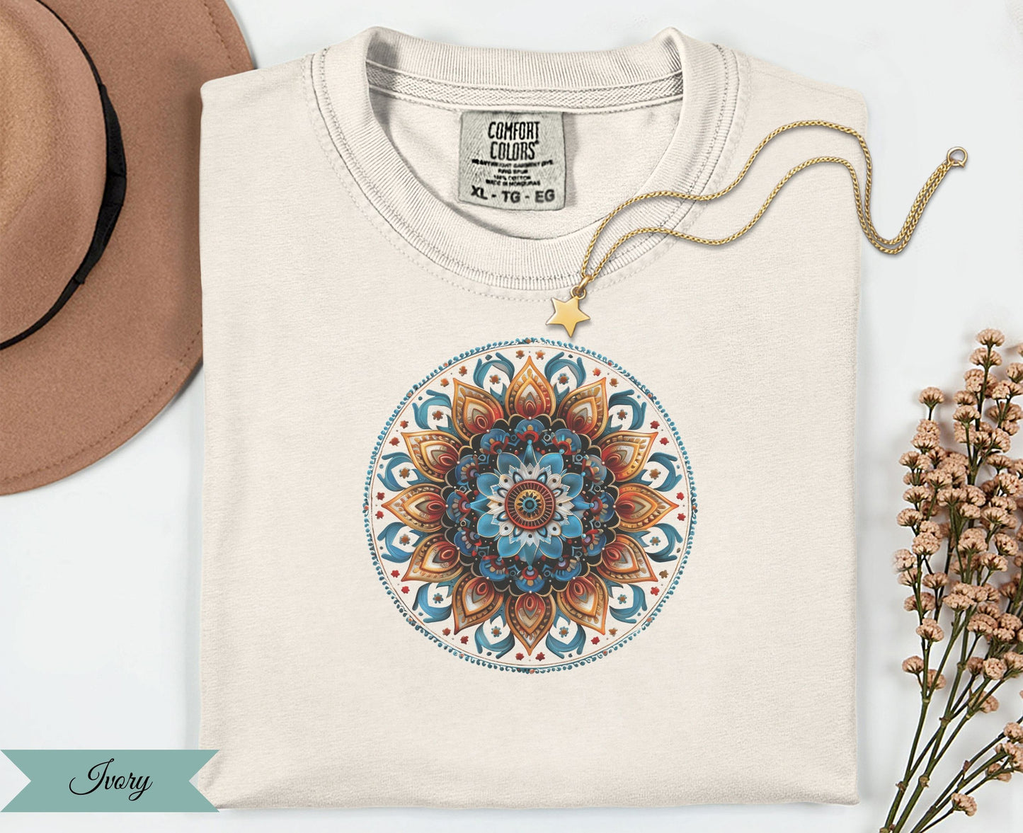 Cream t-shirt with a colorful mandala design and gold star necklace.