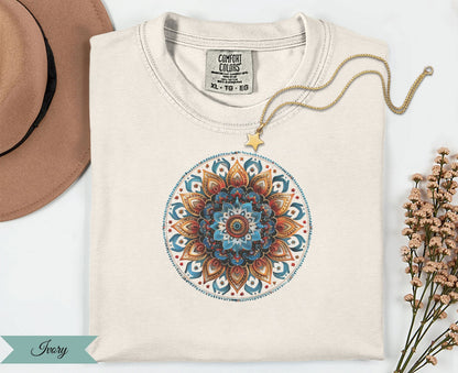 Cream t-shirt with a colorful mandala design and gold star necklace.
