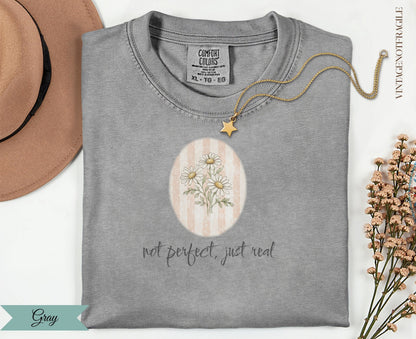 Gray Comfort Colors t-shirt with floral daisy design and "not perfect, just real" text.