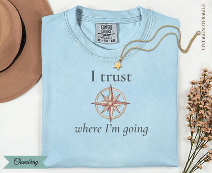 Light blue t-shirt with compass graphic and text "I trust where I'm going".