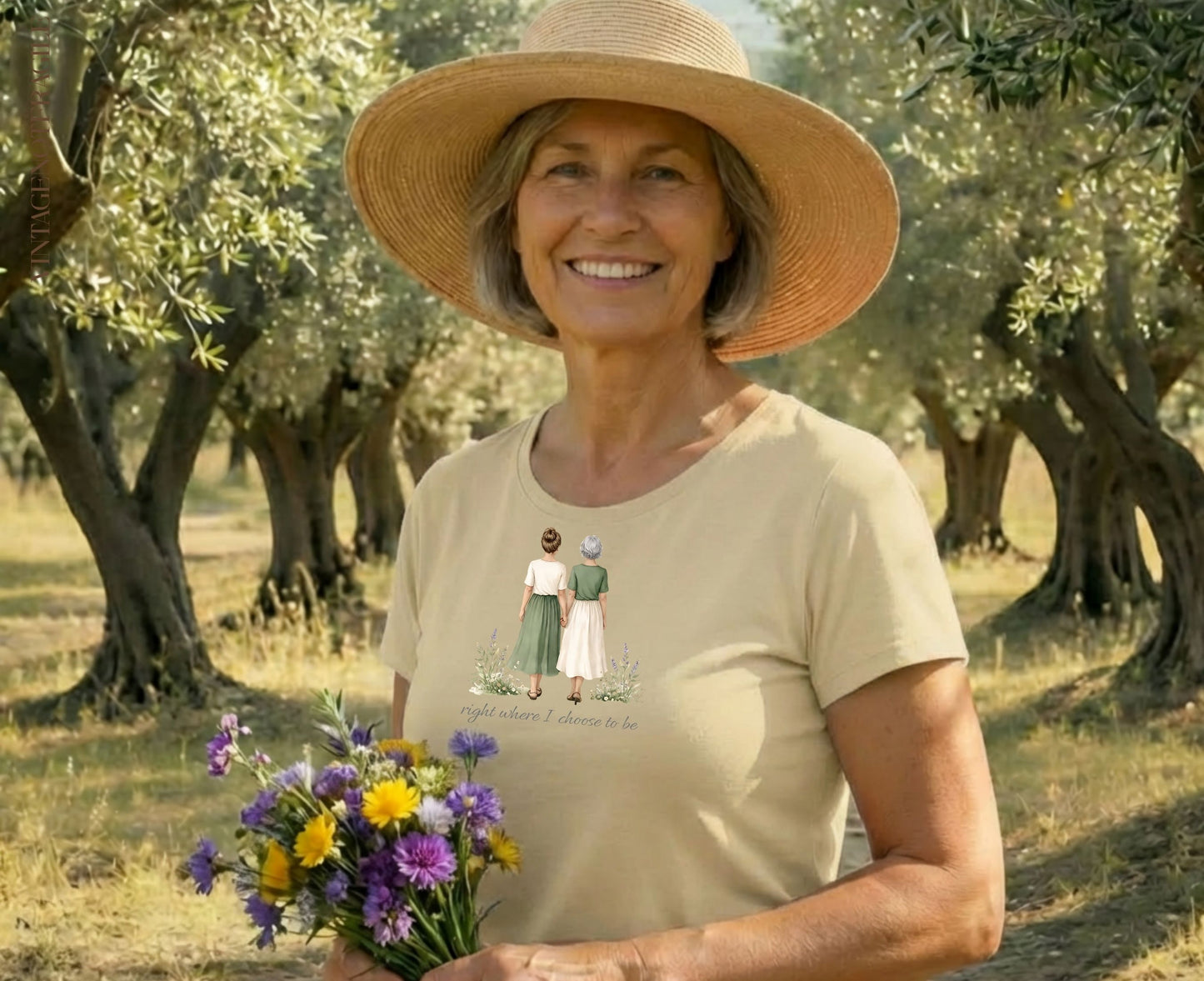 Woman in straw hat holding flowers, wearing shirt with illustration.