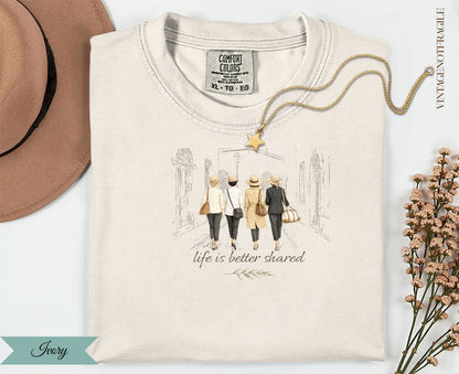 Cream t-shirt with three women walking, "life is better shared" text.