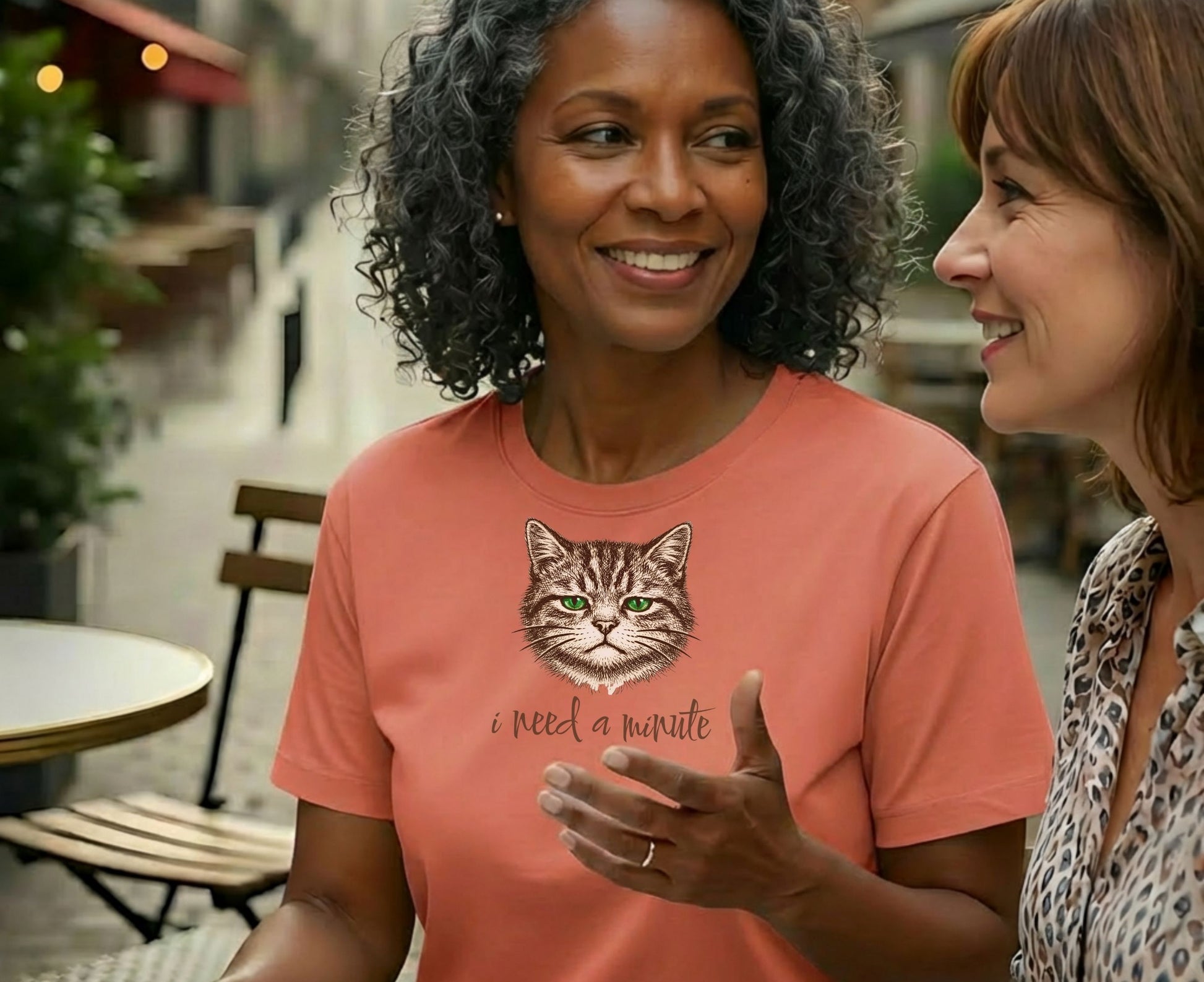 Coral t-shirt with a cat graphic and text "I need a minute".