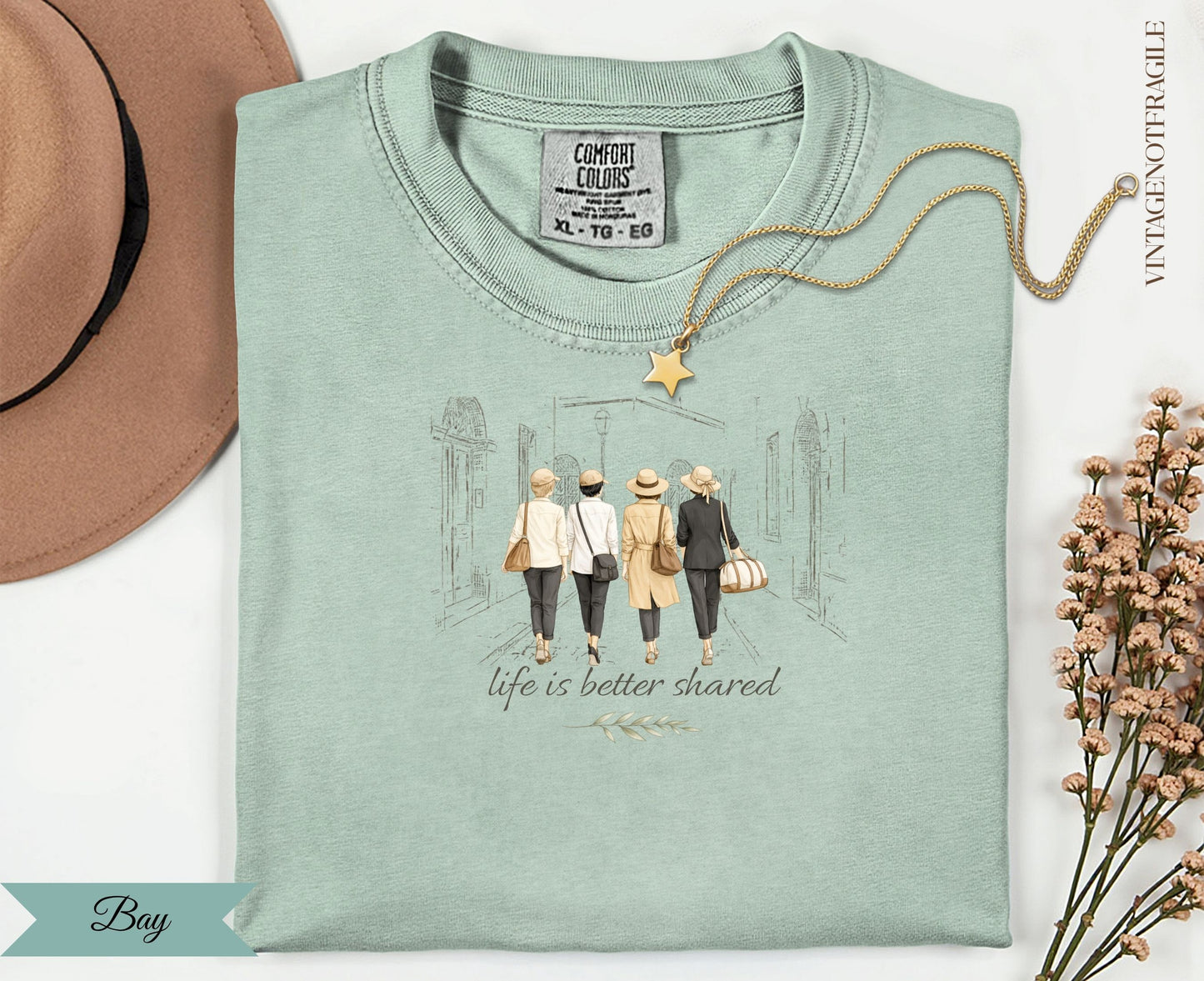 Mint green t-shirt with "life is better shared" graphic and gold star necklace.