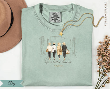 Mint green t-shirt with "life is better shared" graphic and gold star necklace.