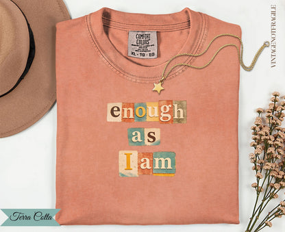 Peach t-shirt with "enough as I am" in colorful block letters.