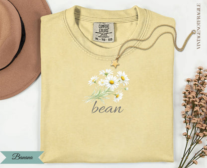 Light yellow t-shirt with "bean" and a daisy bouquet graphic.