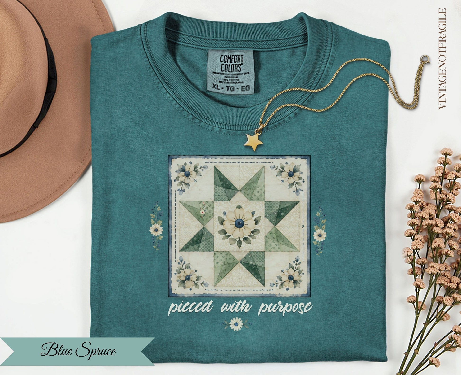 Teal t-shirt with "pieced with purpose" text and a quilt design.