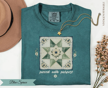 Teal t-shirt with "pieced with purpose" text and a quilt design.
