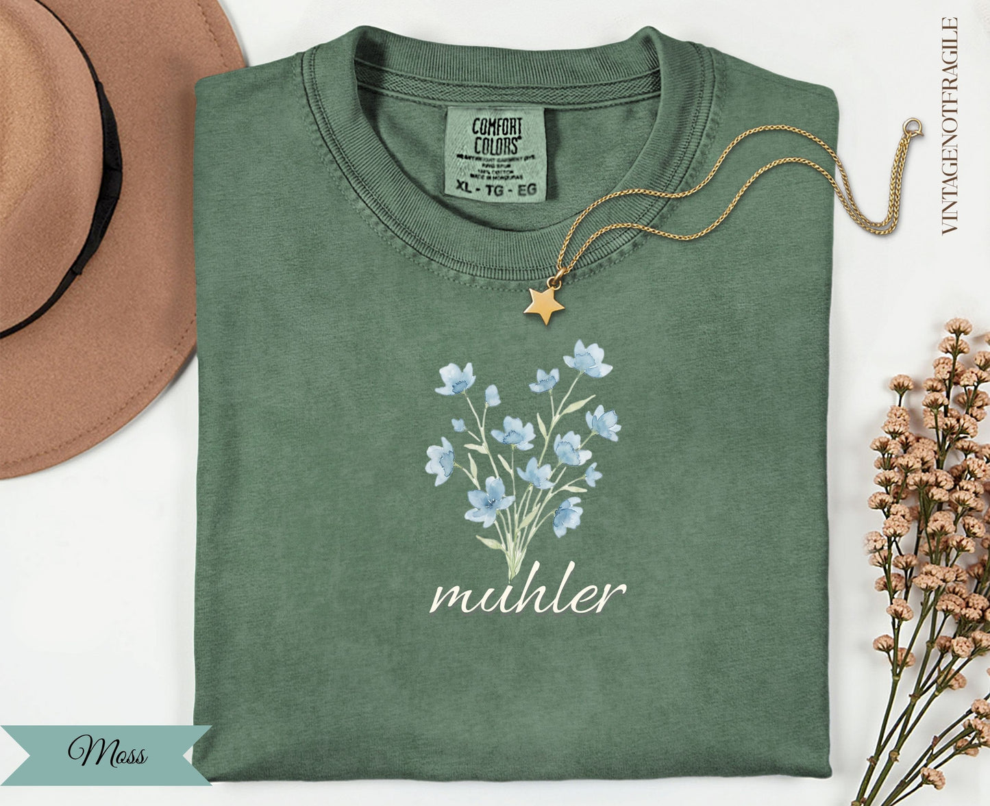 Green t-shirt with blue floral design and "muhler" text.