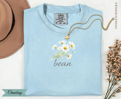 Light blue t-shirt with daisy bouquet and "bean" text.