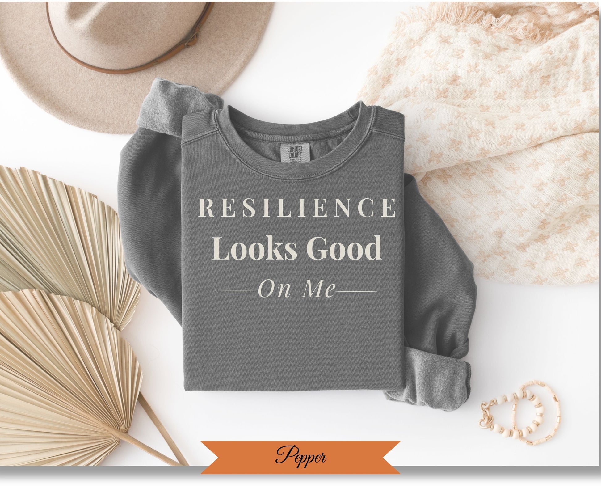Comfort Colors graphic sweatshirt with "Resilience Looks Good On Me" text.