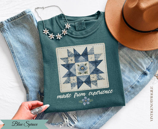 Teal t-shirt with blue quilt design and "made from experience" text.