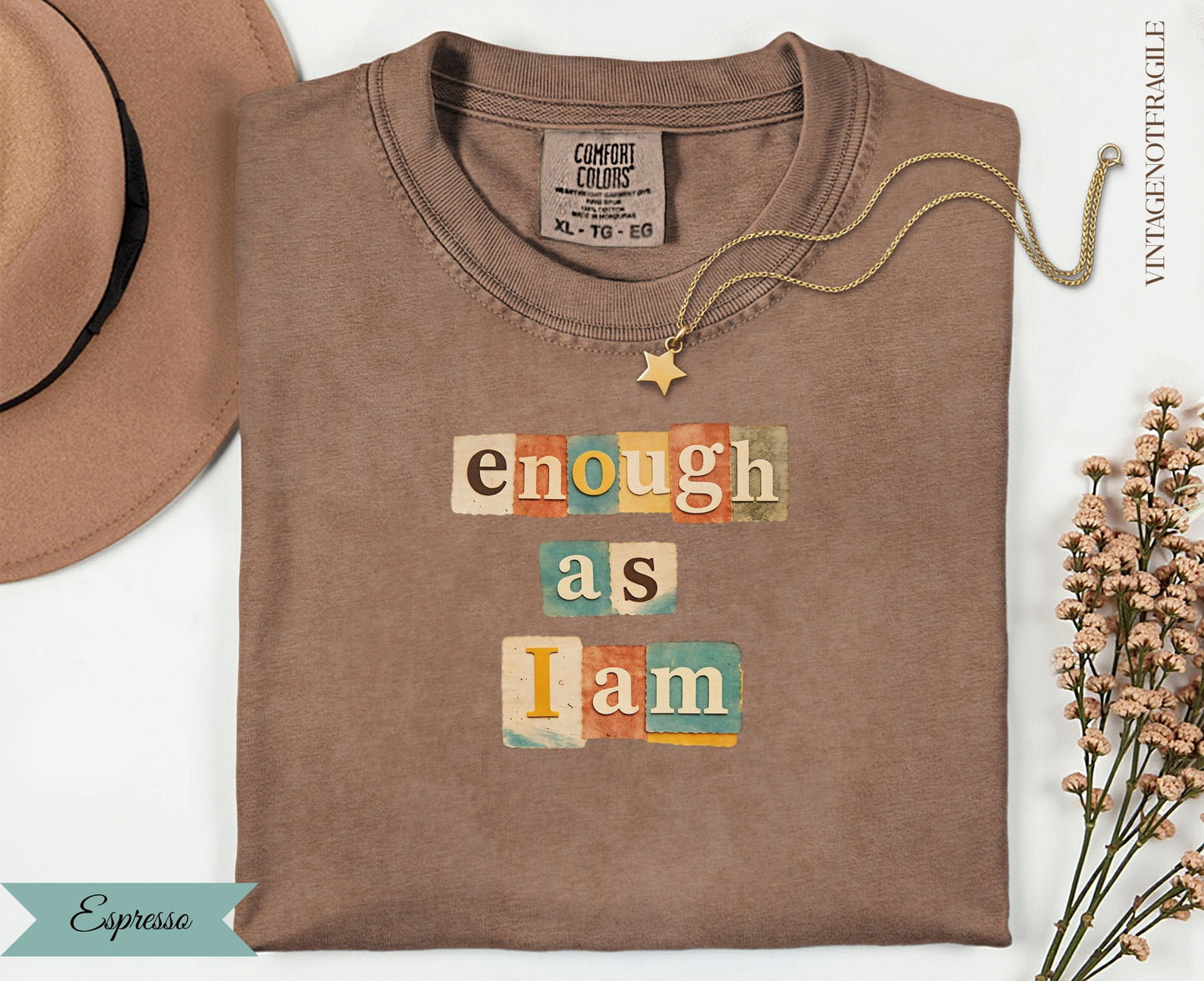 Brown t-shirt with "enough as I am" text in colorful blocks, gold necklace.