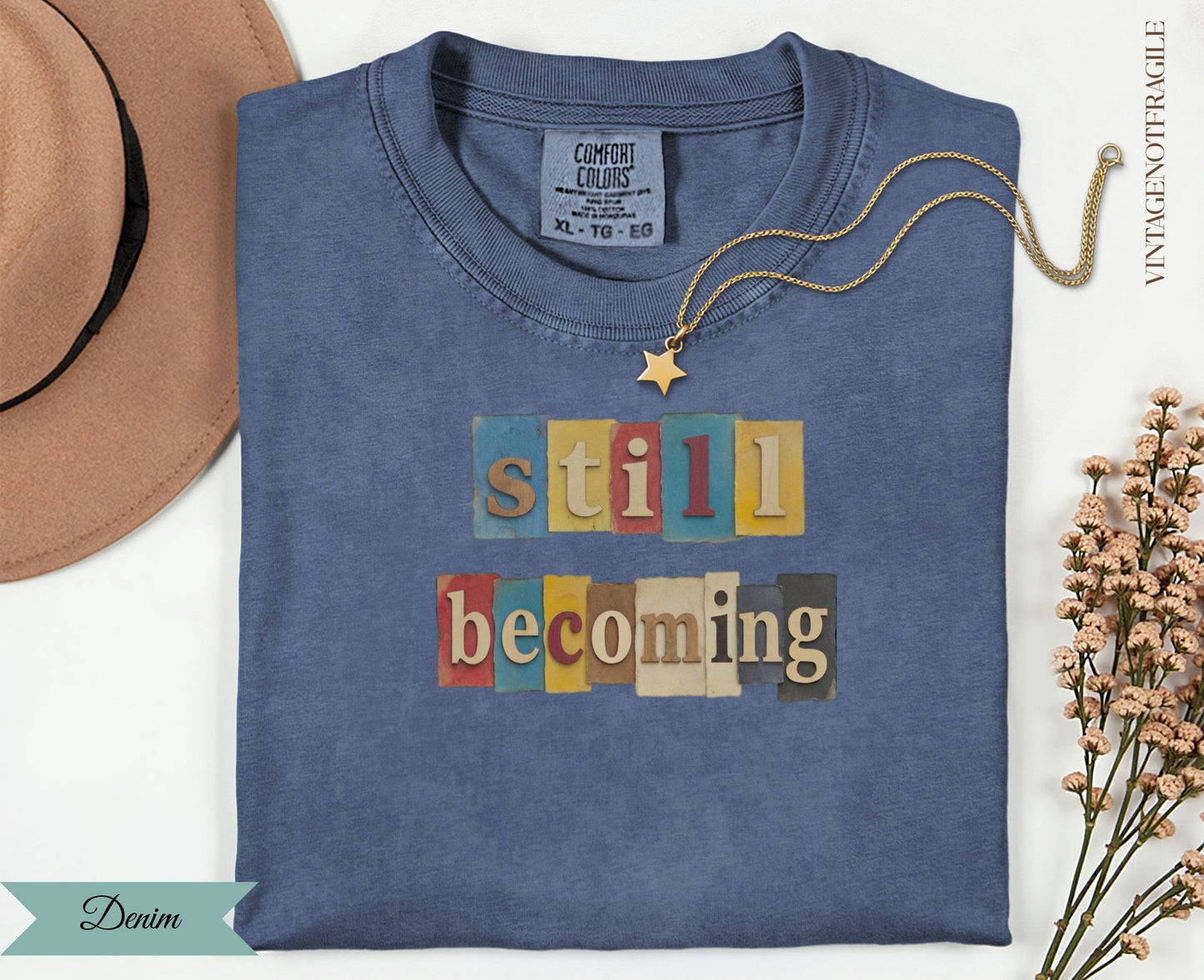 Denim t-shirt with "still becoming" text in colorful block letters.
