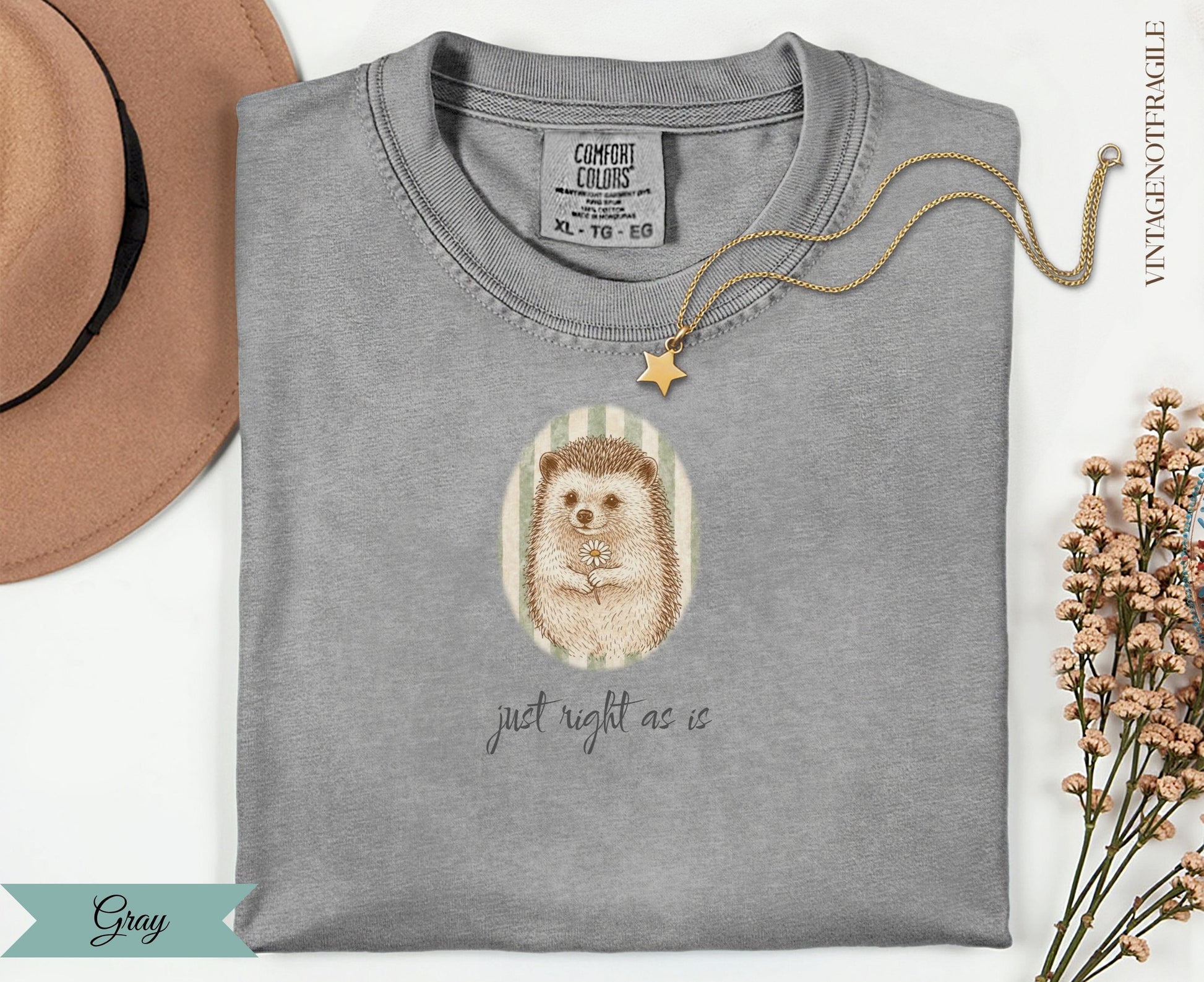 Gray t-shirt with hedgehog holding a daisy, text "just right as is."