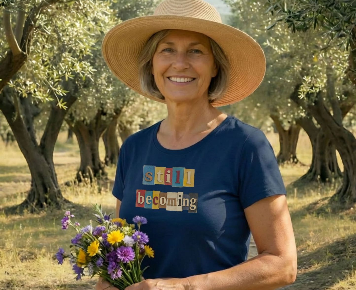 Woman in hat holds flowers, wearing a shirt with colorful text.