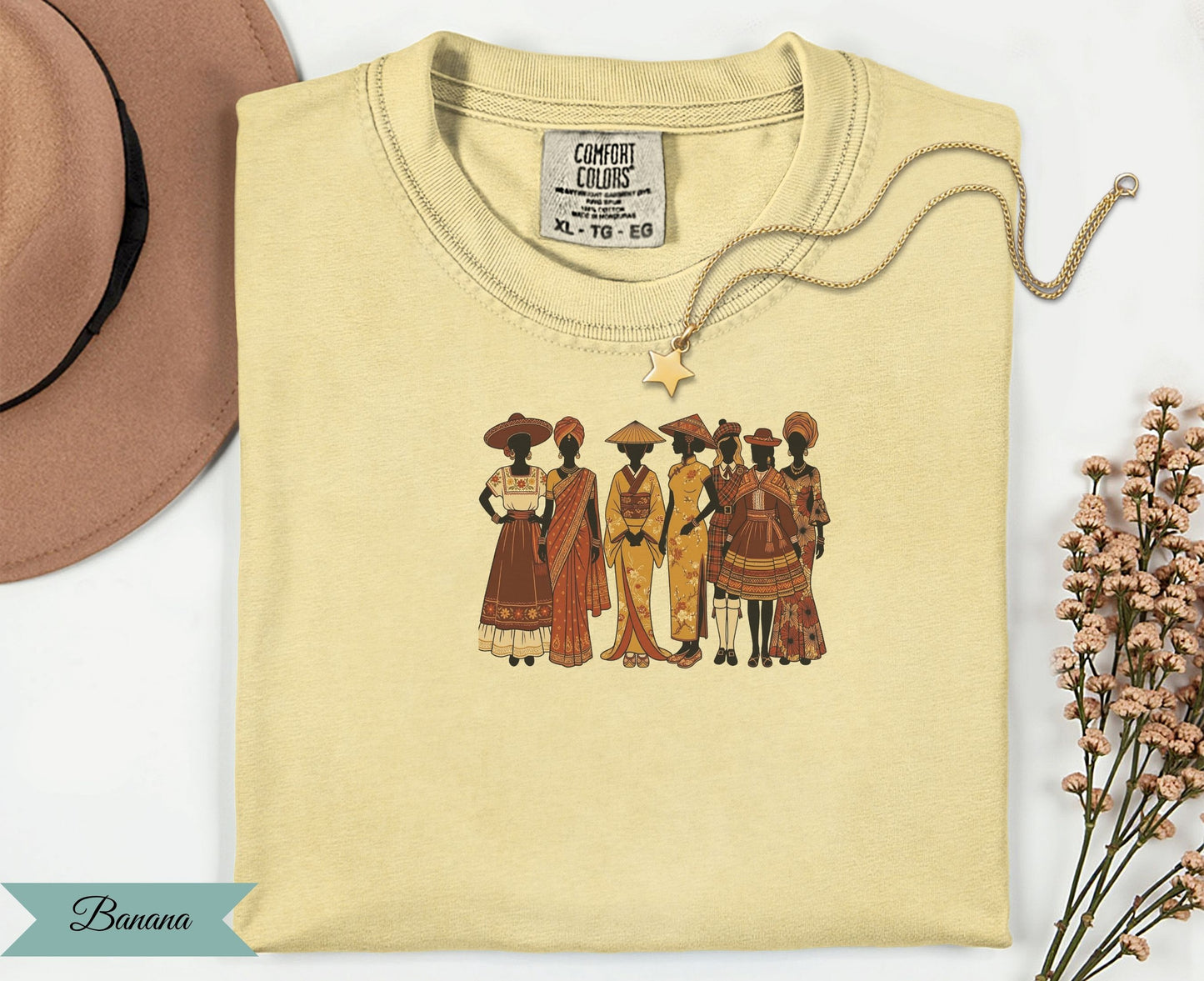 T-shirt featuring diverse women in traditional attire, with a gold necklace and hat.